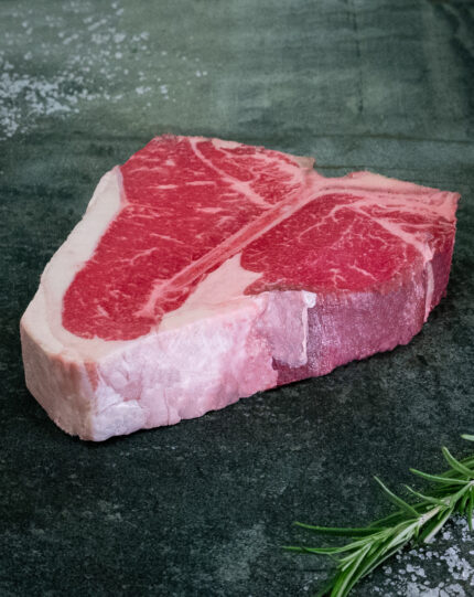 Creekstone Farms US Porterhouse Steak mit großem Filet-Anteil für Gezer Gastro-Kunden, präsentiert auf Schieferplatte.