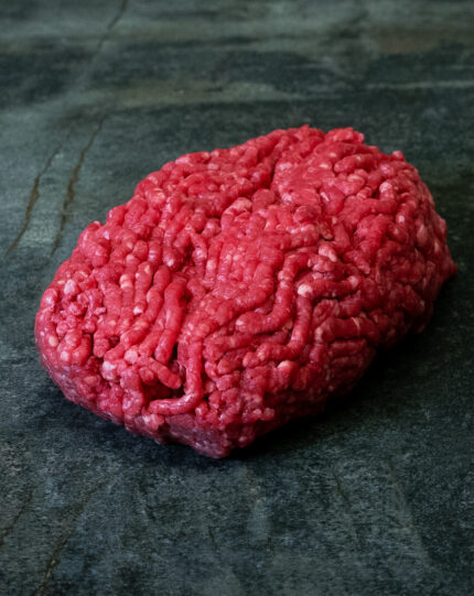 Rohes Hackfleisch Creekstone Farms USA auf einer schwarzen Schieferplatte.