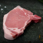 Kotelett vom Duroc-Schwein aus der Region, hochwertig präsentiert auf einer Schieferplatte für Gezer Kunden.