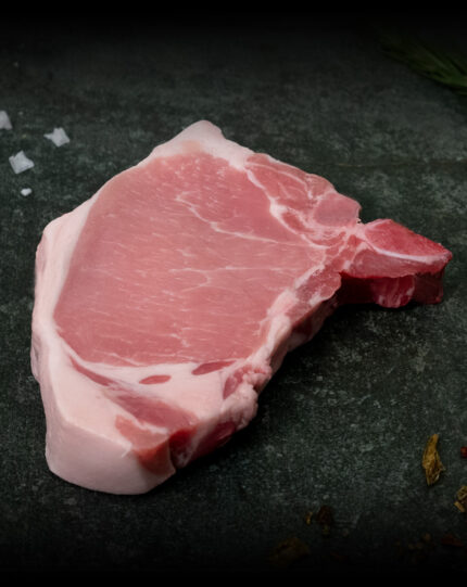Kotelett vom Duroc-Schwein aus der Region, hochwertig präsentiert auf einer Schieferplatte für Gezer Kunden.
