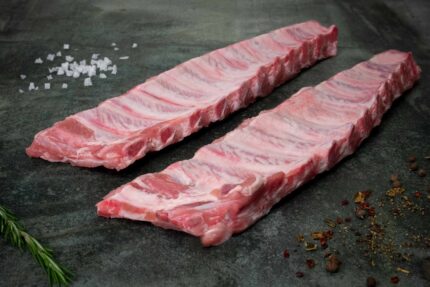 Rohe Spareribs vom Duroc-Schwein auf einer schwarzen Schieferplatte für Gezer Gastronomie-Kunden.