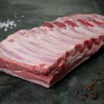 Frische St. Louis Ribs vom regionalen Duroc auf Schieferplatte präsentiert von Gezer.