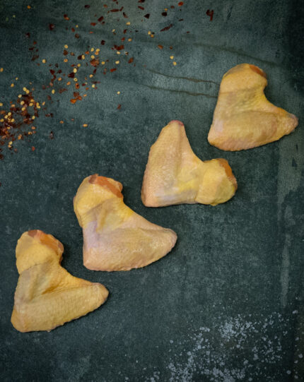 Rohe Kikok Chicken Wings (Hähnchenflügel) auf einer schwarzen Schieferplatte für Gezer Gastronomie-Kunden.