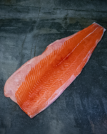 Ein ganzes rohes Lachsfilet aus Norwegen auf einer schwarzen Schieferplatte für Gezer Kunden aus der Gastronomie.