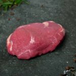 Rohe Lammhüfte aus Neuseeland auf einer schwarzen Schieferplatte für Gezer Gastronomie-Kunden.