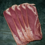 Rinderbacon von der Pommern-Färse, ansprechend auf einer Schieferplatte präsentiert für Gastronomie-Kunden.