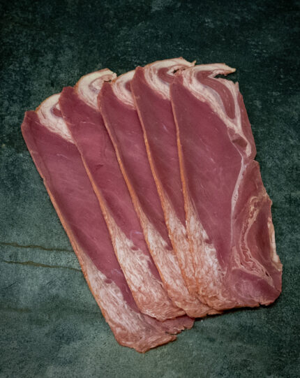 Rinderbacon von der Pommern-Färse, ansprechend auf einer Schieferplatte präsentiert für Gastronomie-Kunden.