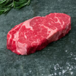 Rohes Black Angus Ribeye Steak aus Argentinien auf einer schwarzen Schieferplatte für Gastronomie-Kunden von Gezer.