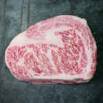 Rohes Wagyu Ribeye Nozaki Kagoshima A5 auf schwarzer Schieferplatte.