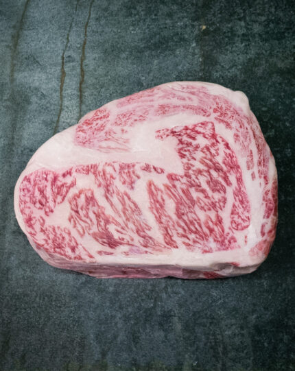 Rohes Wagyu Ribeye Nozaki Kagoshima A5 auf schwarzer Schieferplatte.