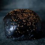 Tiefschwarzer BEKABUN No. 3 Burger Bun, kontrastreich auf einer Schieferplatte präsentiert für Gezer Gastro-Kunden.