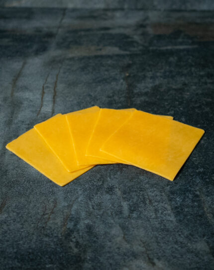 Cheddar-Käse in Scheiben, fächerförmig auf einer Schieferplatte präsentiert für Gezer Kunden.