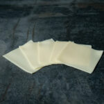 Junger Gouda in Scheiben für Gezer Gastronomie-Kunden, präsentiert auf Schieferplatte.