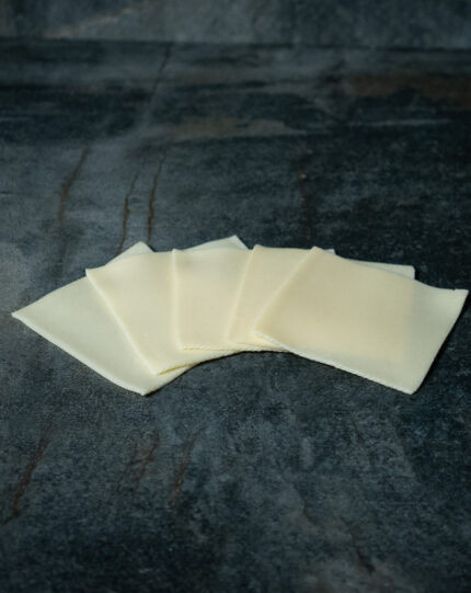 Junger Gouda in Scheiben für Gezer Gastronomie-Kunden, präsentiert auf Schieferplatte.