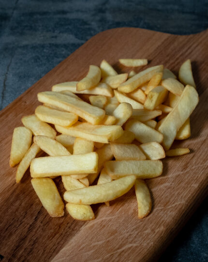 Aviko Steakhouse Pommes, breit geschnitten auf einer Schieferplatte präsentiert für Gezer Kunden.