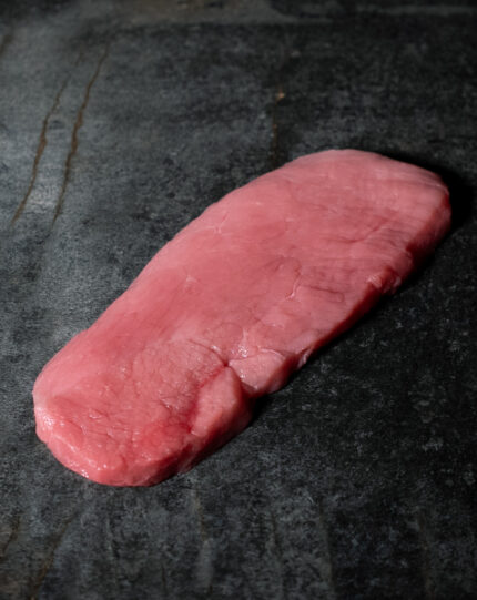 Schnitzel vom regionalen Duroc-Schwein, fachgerecht zugeschnitten auf einer Schieferplatte präsentiert für Gezer Kunden.