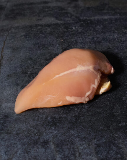 Kikok Hähnchenbrust vom Maishähnchen, mit charakteristischer goldgelber Farbe auf einer Schieferplatte präsentiert für Gezer Gastro-Kunden.