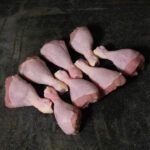 Chicken Drumsticks (Hähnchenunterkeulen), appetitlich auf einer Schieferplatte präsentiert für Gezer Gastronomie-Kunden.