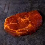 Duroc Schweinenackensteak pikant mariniert, hochwertig auf einer Schieferplatte präsentiert für Gezer Kunden.