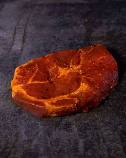 Duroc Schweinenackensteak pikant mariniert, hochwertig auf einer Schieferplatte präsentiert für Gezer Kunden.