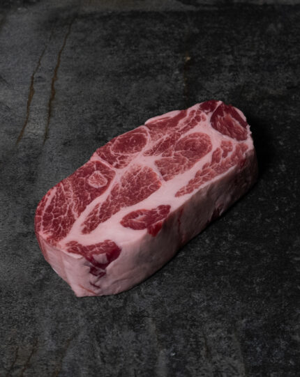 Rohes Nackensteak vom Iberico-Schwein, reich marmoriert auf einer Schieferplatte präsentiert für Gezer Kunden.