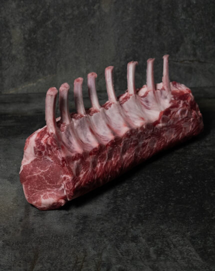 Rohes Schweinekarree vom Ibérico-Schwein, fachgerecht pariert mit Knochen auf einer Schieferplatte präsentiert für Gezer Kunden.