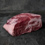 Roher Nacken ohne Knochen vom Iberico-Schwein, stark marmoriert auf einer Schieferplatte präsentiert für Gezer Kunden.