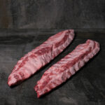 Rohe Spareribs vom Ibérico-Schwein, mit feiner Fettmarmorierung auf einer Schieferplatte präsentiert für Gezer Kunden.