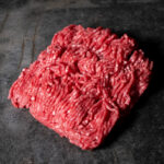 Hackfleisch gemischt - Rind & Schwein, frisch gekörnt auf einer Schieferplatte präsentiert für Gezer Kunden.