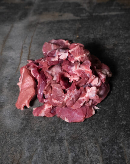 Wildschweingulasch, ungewürzte und handgeschnittene Fleischwürfel auf einer Schieferplatte präsentiert für Gezer Kunden.