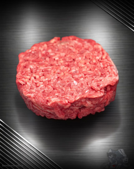 Rohes Haché Schweine-Burger Pattie aus grob gehacktem Schweinefleisch mit sichtbarer Struktur auf neutralem Untergrund.